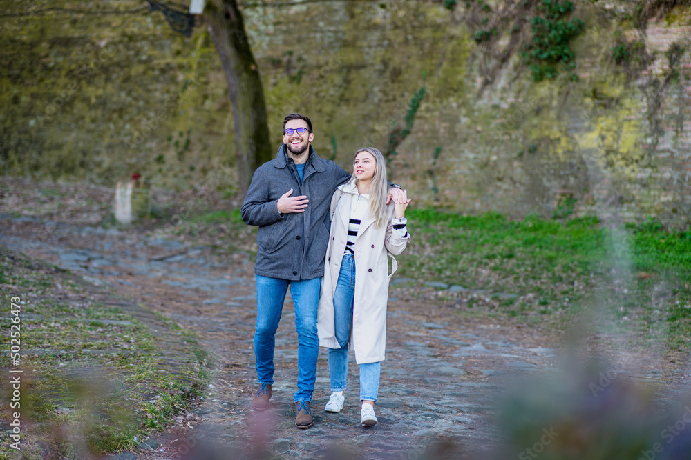 Fototapeta premium A portrait of a happy romantic couple walking outdoors in the surroundings of an old fortress