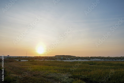 Sun setting on a beach tidal estuary