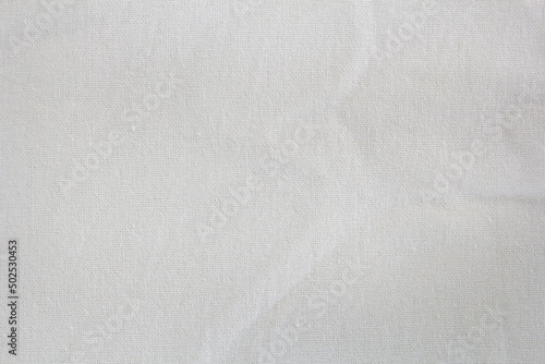 White textile cloth with streak design and wrinkles for the background.