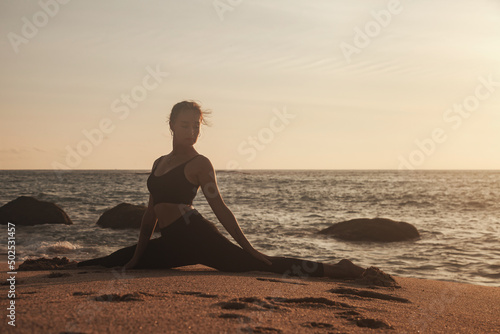Young woman does yoga for healthy lifestyle on sea beach © Alex Vog
