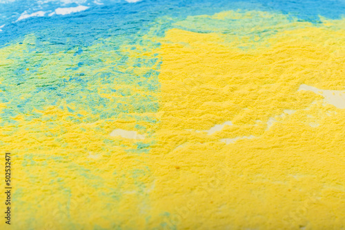 Ukrainian flag colours. The concept of war in Ukraine. Blue and yellow background from holi powder paint.