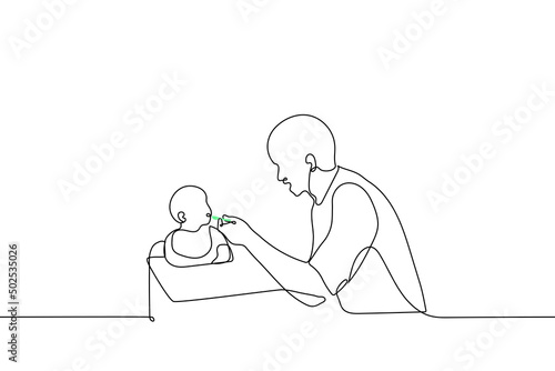 young father feeding baby sitting in baby chair - one line drawing vector. concept of single father feeding baby with spoon, male nanny, babysitter