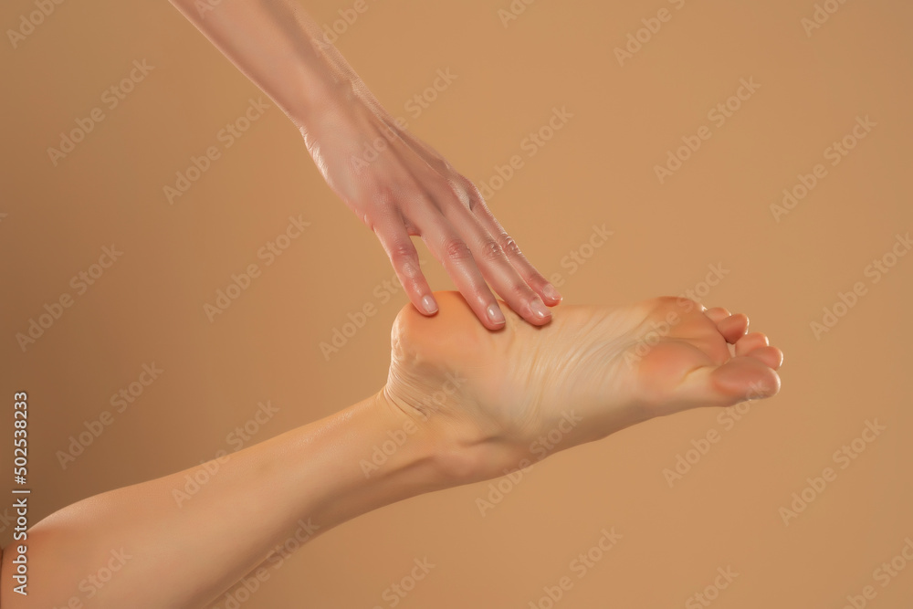 Fototapeta premium Perfect clean female feet . Beautiful and elegant groomed woman's hand touching her foot . Spa ,scrub and foot care