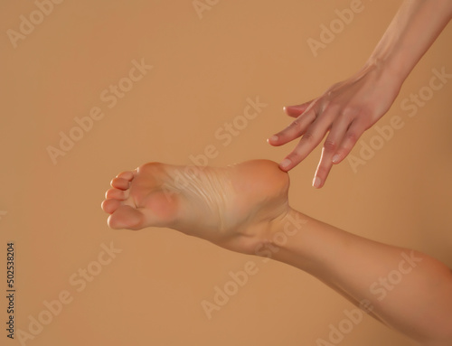 Perfect clean female feet . Beautiful and elegant groomed woman's hand touching her foot . Spa ,scrub and foot care