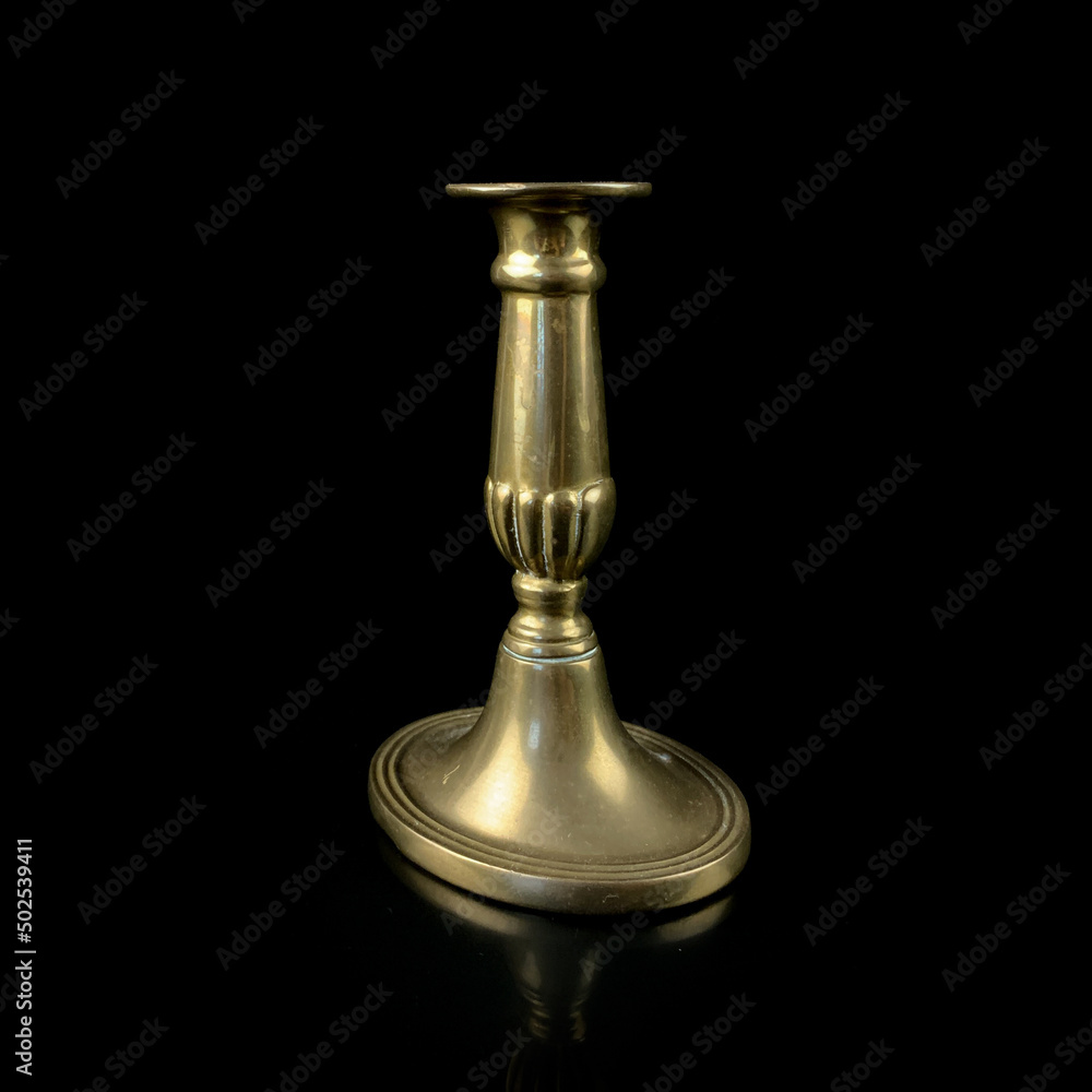 copper antique candlestick with burning candles. vintage golden candlestick on black isolated background