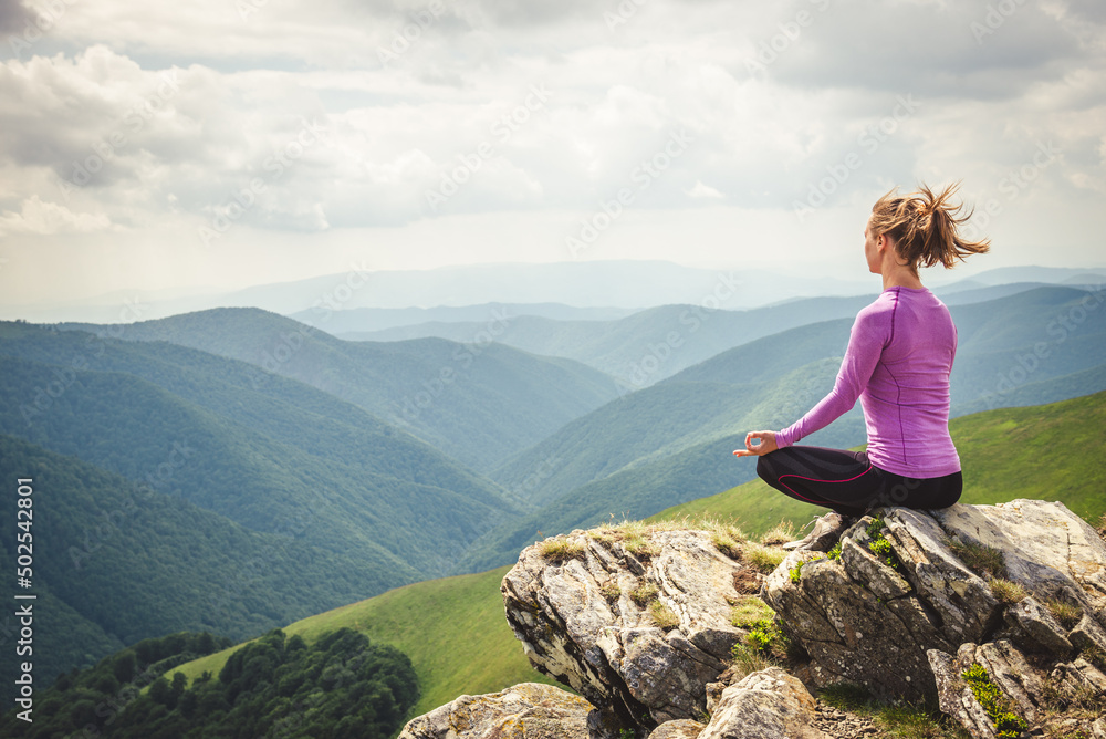 Young woman on the top of mountain