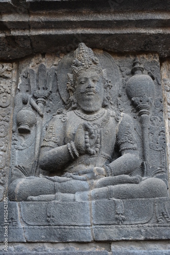 ancient buddha statue - stone carving on the walls of the temple of Prambanan near Yogyakarta  Central Java  Indonesia