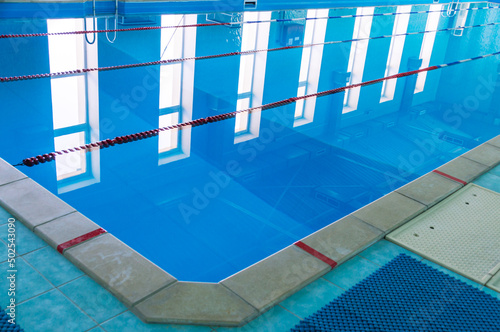 Swimming pool with clear blue water. Swimming paths in the pool. Swimming pool for water sports. Water in the pool.