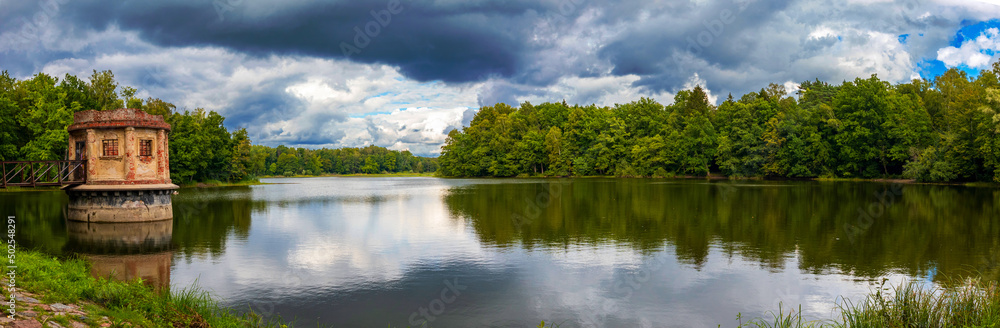 panoramic view of the lake surrounded by trees. round tower in the Willgaiten pond in the Kaliningrad region