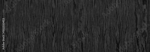 Black wood grain wide panoramic texture. Dark gray plywood large long backdrop. Wooden surface pattern abstract banner background