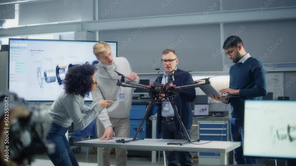 Diverse Aviation Engineers Work Together on a New Drone, Have Active Discussion, Use Gadgets In the Scientific Laboratory. Startup and Innovations Concept Diverse Aviation Engineers Work Together on a New Drone, Have Active Discussion, Use Gadgets In the Scientific Laboratory. Startup and Innovations Concept