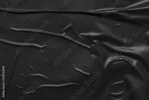 black crumpled and creased plastic poster texture background