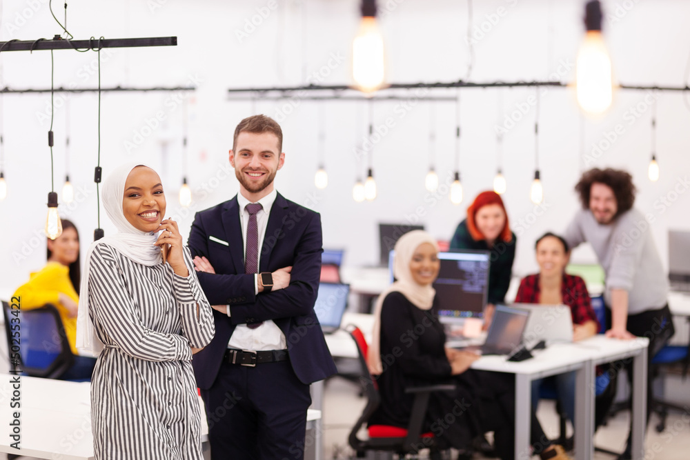 Two multiethnic colleagues in a modern office space. Group of people working in the background Diversity and success concept.. Two multiethnic colleagues in a modern office space. Group of people working in the background Diversity and success concept..