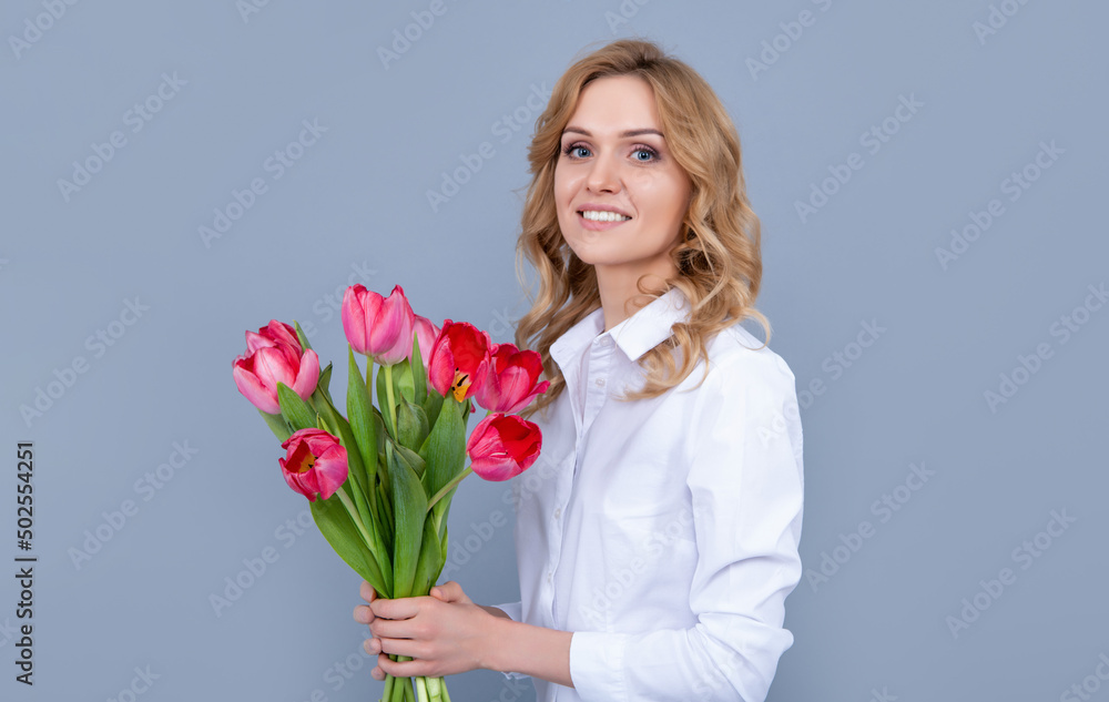 young woman smile with spring tulip bouquet on grey background young woman smile with spring tulip bouquet on grey background