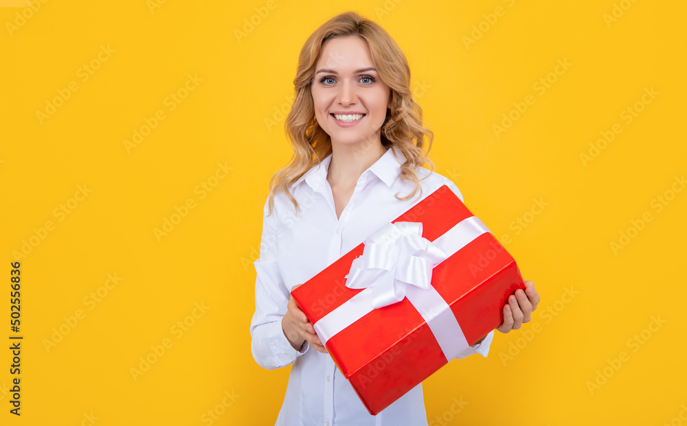 glad woman with big present box on yellow background glad woman with big present box on yellow background