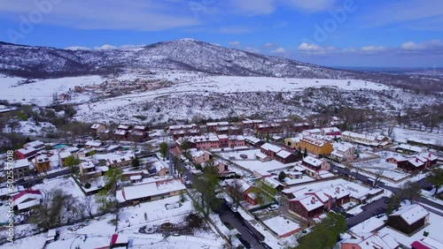 Pull out aerial view over the snow-covered countryside of Pradera de Navalhorno in Spain photo