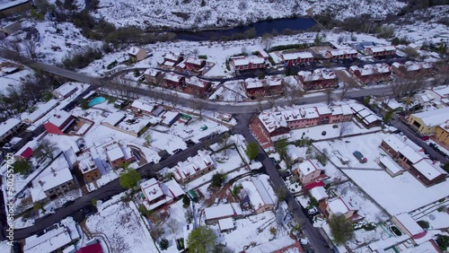 High angle birdseye view over the homes and buildings of Pradera de Navalhorno on a chilly snow-covered winter's day. photo