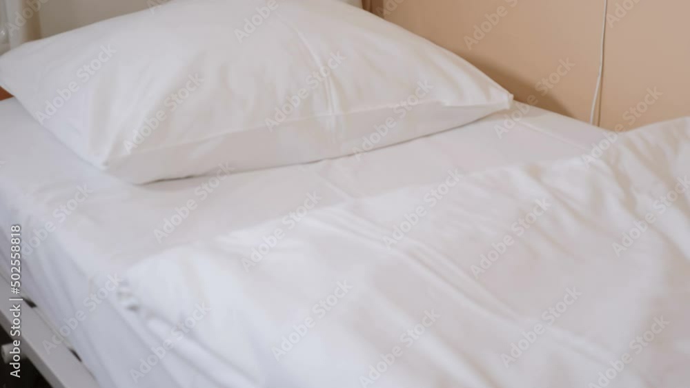 Empty hospital bed with white bedclothing. white pillow, sheet and