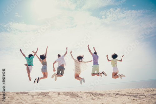 Photo of funny charming six young buddies dressed casual outfits rising arms jumping high outdoors countryside
