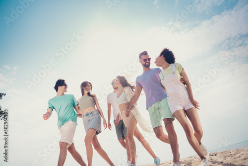 Photo of glad nice carefree friends group walk sunny weather wear casual outfit nature summer seaside beach