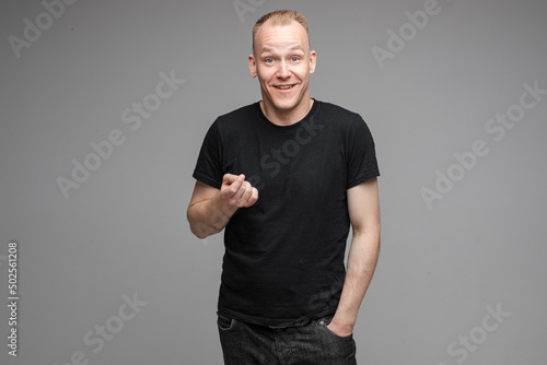 Serious man gesturing while posing in grey background