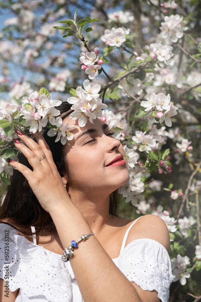 Young caucasian woman enjoying the flowering of an apple trees Young caucasian woman enjoying the flowering of an apple trees