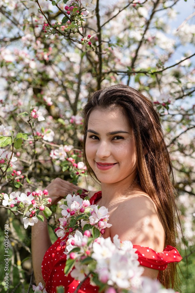 Young caucasian woman enjoying the flowering of an apple trees Young caucasian woman enjoying the flowering of an apple trees