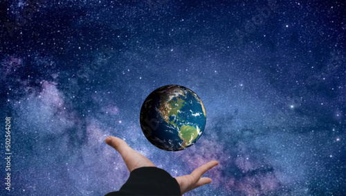 hand with globe by thy sky at night
