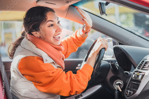 Polite woman driver raised her hand as a sign of respect and says thank you for giving way. Relations between people in traffic regulations