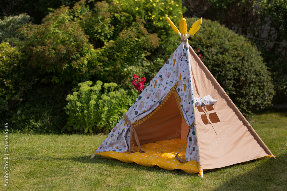 children's tepee tent on a green lawn, outdoor recreation