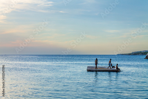 Group of young people are enjoying themselves on a floating dock.