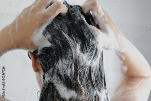 Canvastavla Woman is washing her hair with shampoo