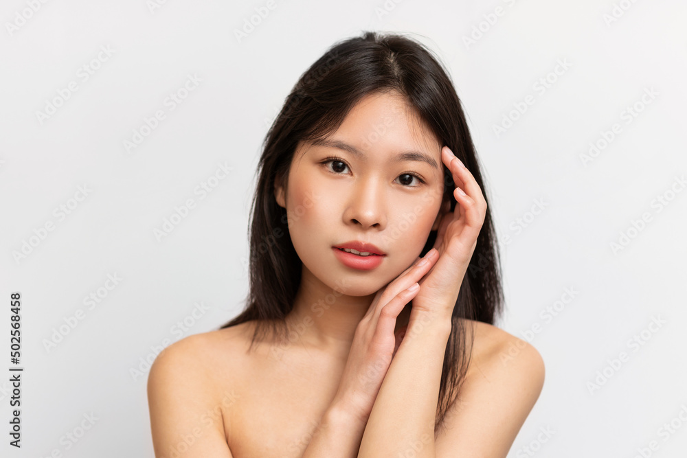 Beauty portrait of young Asian woman touching her clean face Beauty portrait of young Asian woman touching her clean face