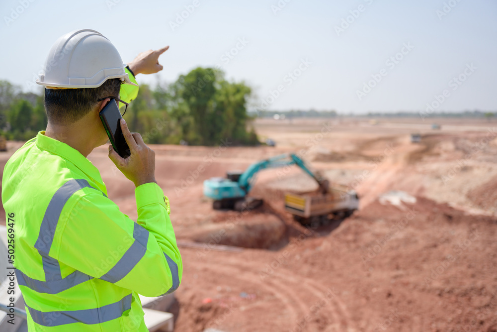 A male engineer working in an industrial estate controls the design of land leveling. and production management in the engineering industry utilities A male engineer working in an industrial estate controls the design of land leveling. and production management in the engineering industry utilities