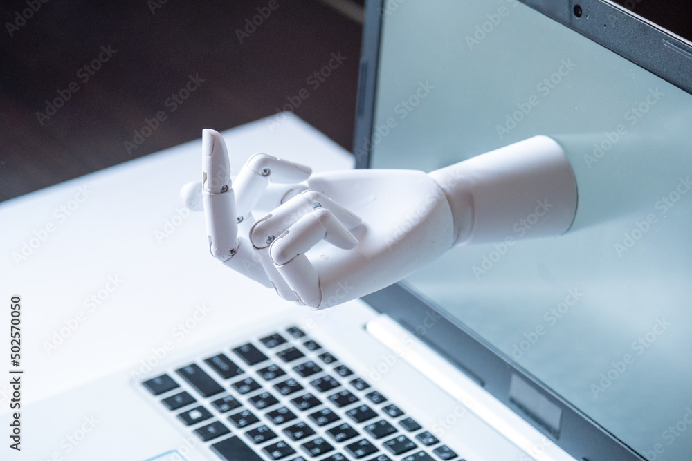 a robot hand with an indecent gesture is visible from the computer monitor. the concept of aggression in social networks and on the Internet. Conflict