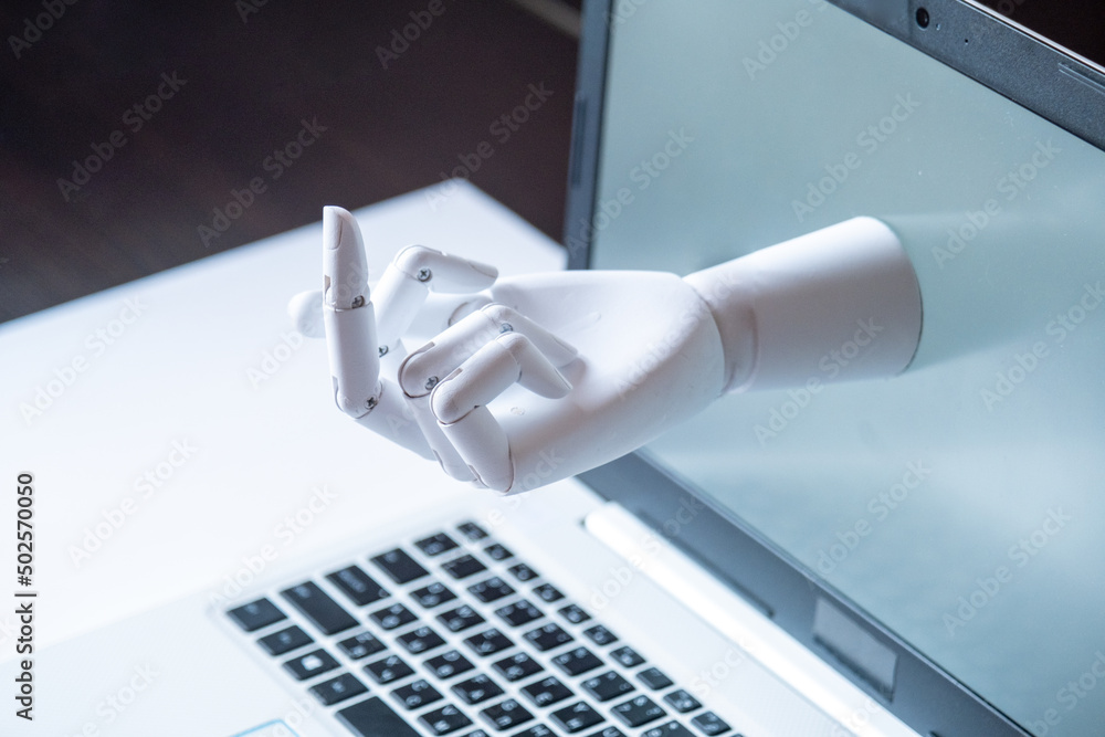 a robot hand with an indecent gesture is visible from the computer monitor. the concept of aggression in social networks and on the Internet. Conflict a robot hand with an indecent gesture is visible from the computer monitor. the concept of aggression in social networks and on the Internet. Conflict
