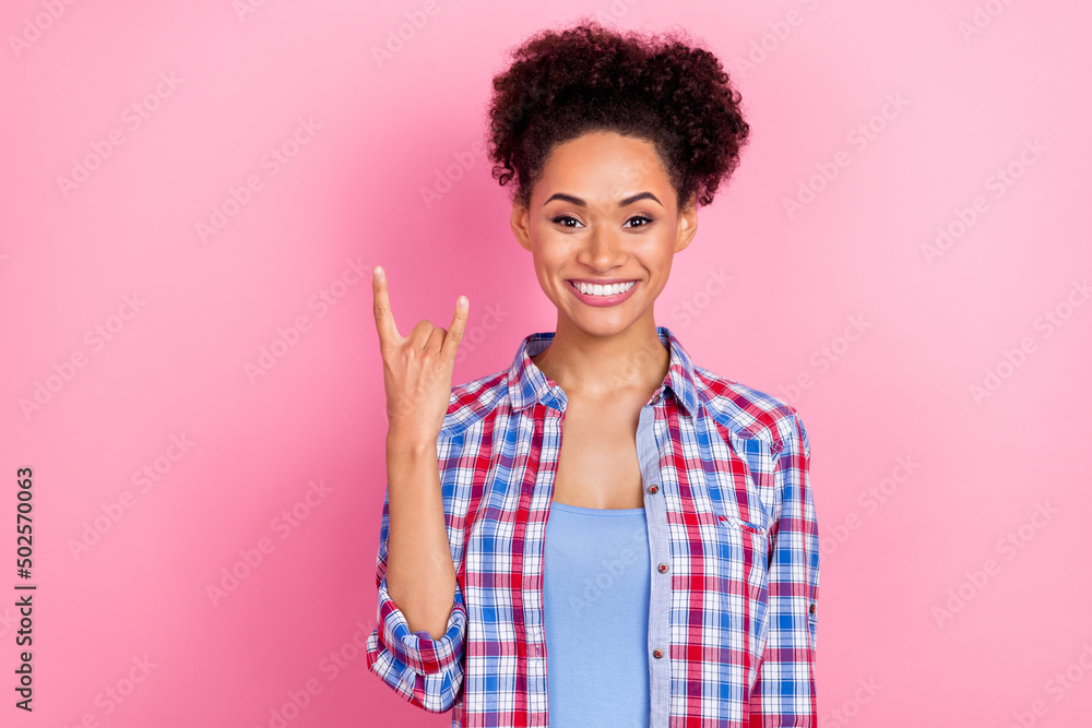 Photo of sweet brunette lady show rock sign wear plaid shirt isolated on pink color background Photo of sweet brunette lady show rock sign wear plaid shirt isolated on pink color background