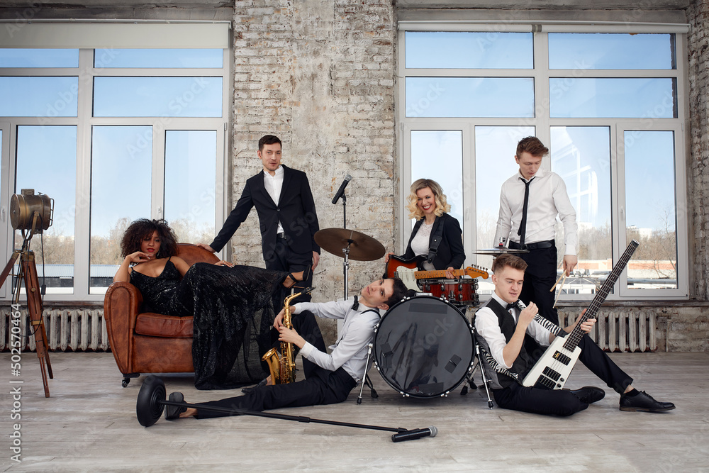 Repetition of multi ethnic jazz band in loft. Bass guitar player