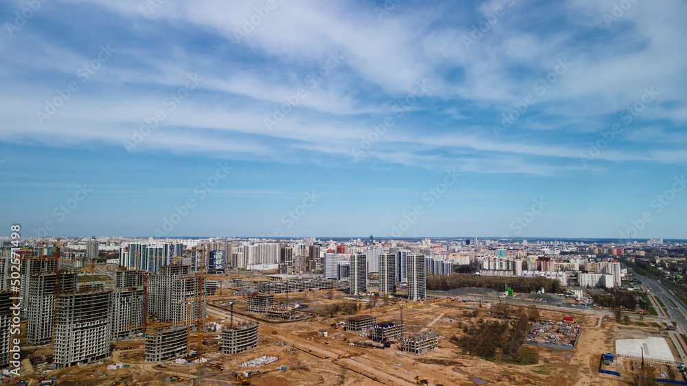 Large construction site. Construction of modern multi-storey residential buildings. Construction of apartment buildings from concrete and glass. Aerial photography.