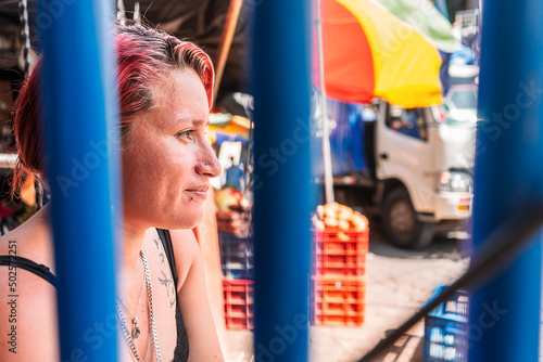 Portrait of a white Latin woman with a modern haircut with piercings on her lips and subtle tattoos in a popular market in Boaco