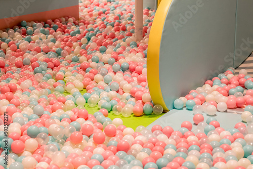 Smal plastic balls for indoor ball pit children kids playground. White blue pink colored background photo