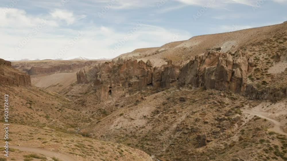 Panning the dirt road across the arid desert, cliffs and mountains. Panning the dirt road across the arid desert, cliffs and mountains.