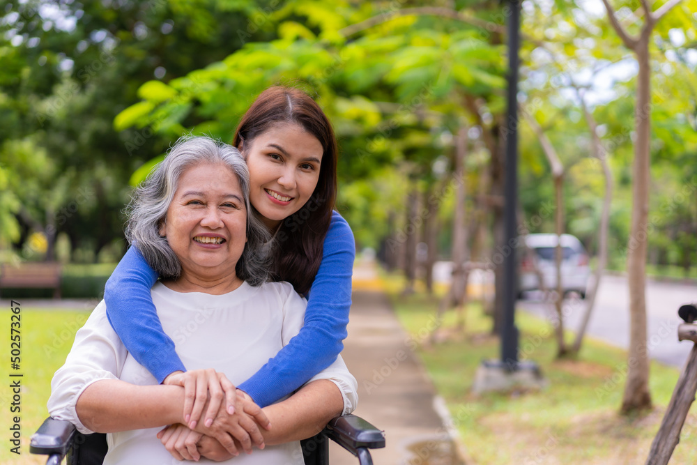Asian careful caregiver or nurse taking care of the patient in a wheelchair. Concept of happy retirement with care from a caregiver and Savings and senior health insurance, a Happy family Asian careful caregiver or nurse taking care of the patient in a wheelchair. Concept of happy retirement with care from a caregiver and Savings and senior health insurance, a Happy family