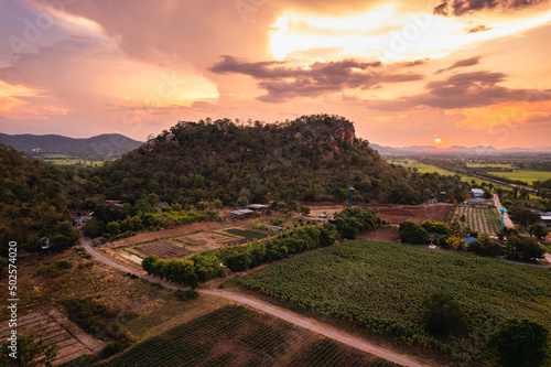 Aerial view of sunset over rural village among the farmland and limestone mountain in countryside