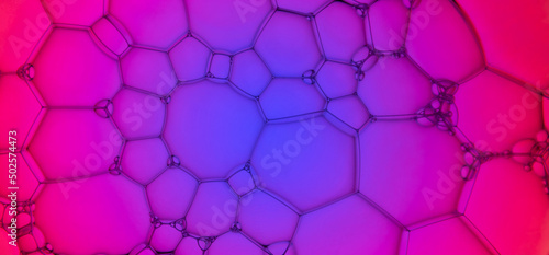The surface of the bubbles. Extreme close-up of soap suds, foam structure on blue and purple. Cosmetic background, web banner format photo