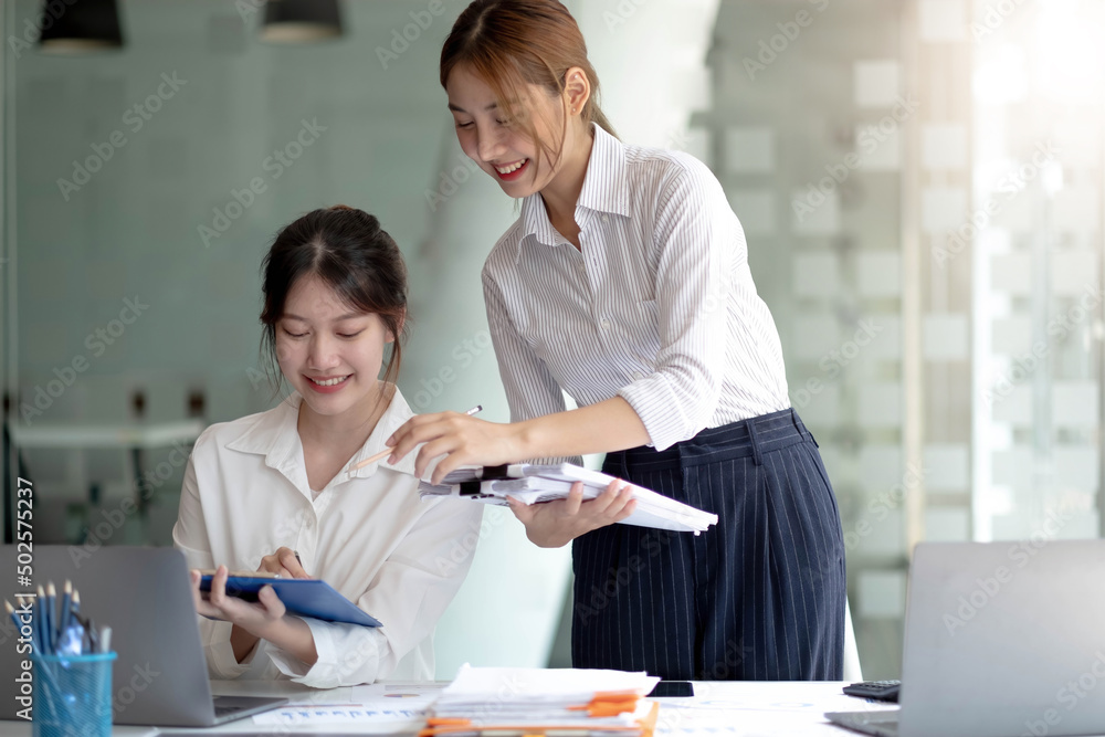 Obraz premium Two Young Asian businesswoman discuss with new startup project Idea presentation, analyze planning and financial statistics and investment market at office.
