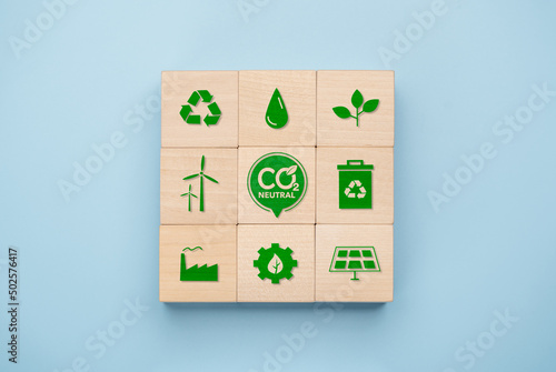 Net Zero and Carbon Neutral Concepts, Net Zero Emissions Goals, Long-Term Climate Neutral Strategies. wooden cube with green net center icon and green icon related to global environment. photo