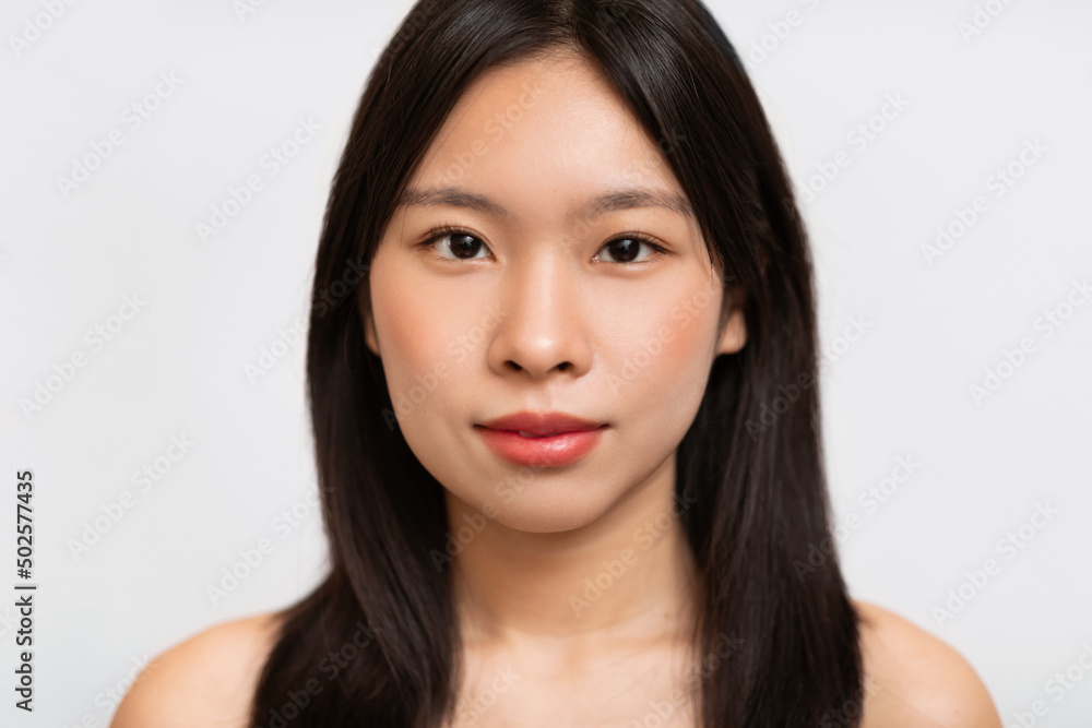 Headshot portrait of young Asian woman posing looking at camera Headshot portrait of young Asian woman posing looking at camera