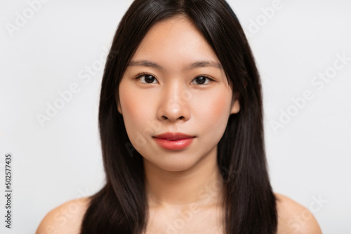 Obraz na plátně Headshot portrait of young Asian woman posing looking at camera