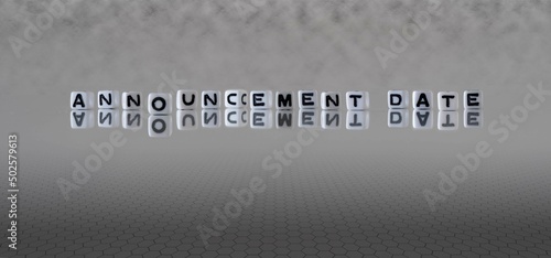 announcement date word or concept represented by black and white letter cubes on a grey horizon background stretching to infinity
